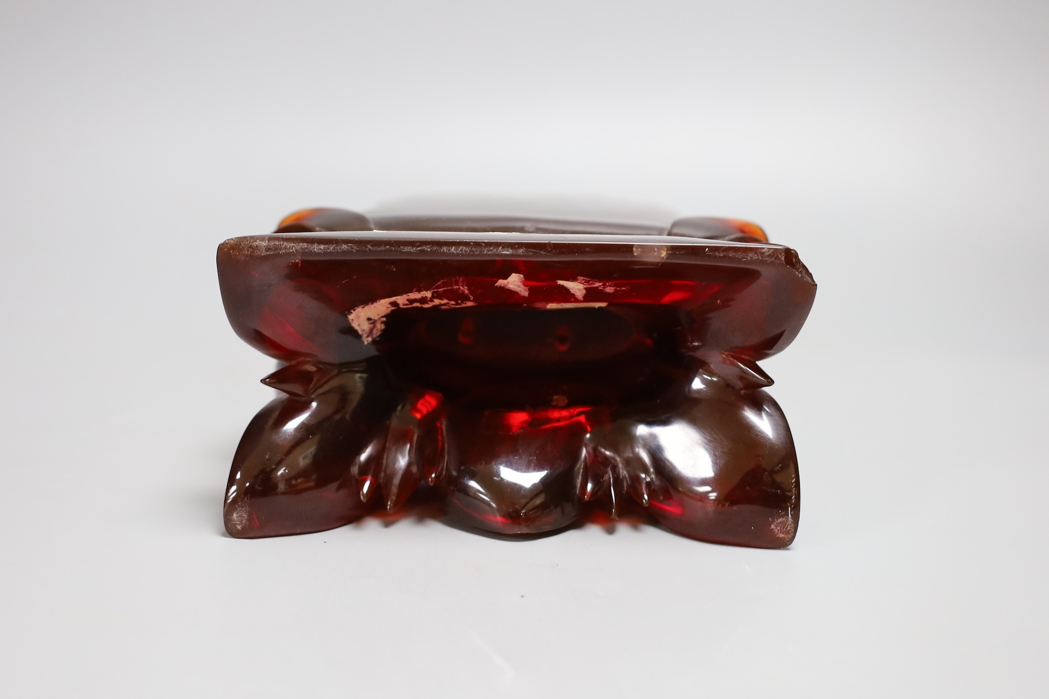 A Chinese ‘cherry amber’ phenolic seated figure of Guanyin, 29cms high